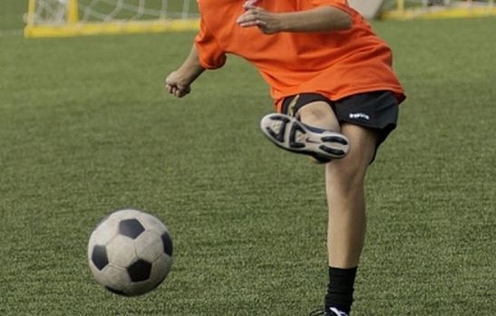 Girl kicks a soccer ball