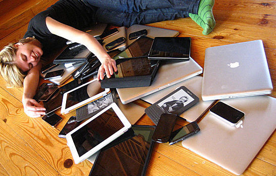 Woman cuddling with multiple digital devices