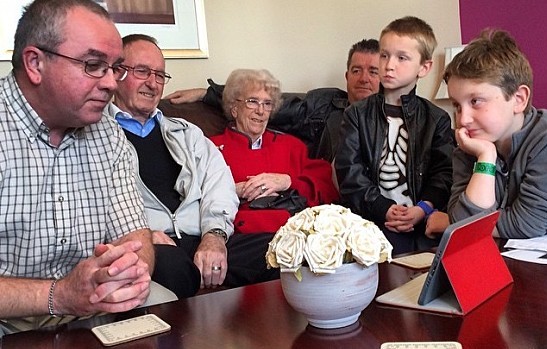 Family sitting around an ipad